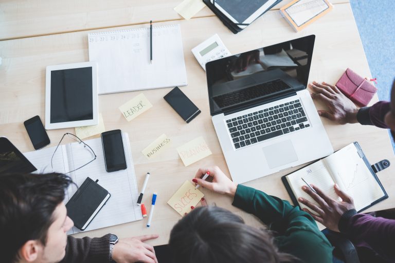 graphicstock top view of working desk with three multiethnic people working business teamwork brainstorming concept rafiD6FJ