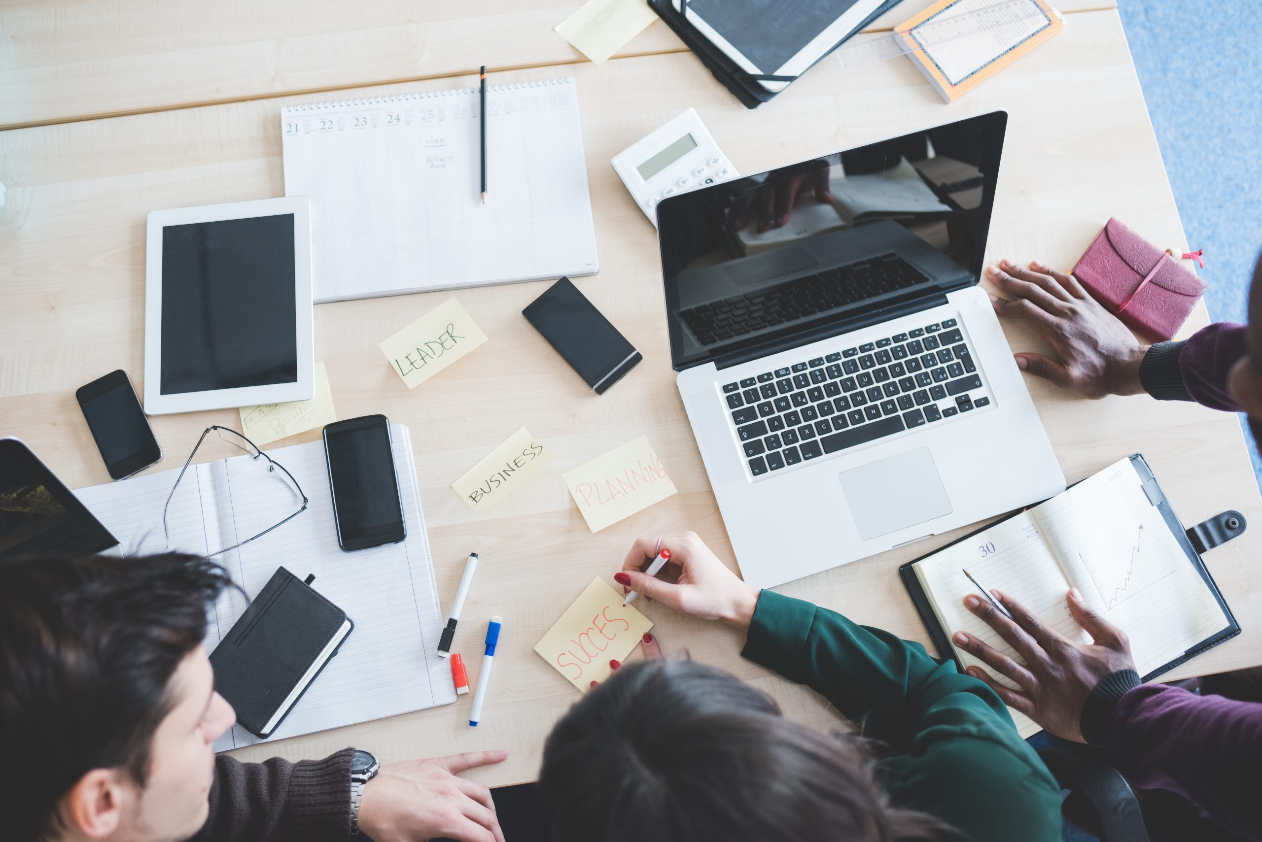 graphicstock top view of working desk with three multiethnic people working business teamwork brainstorming concept rafiD6FJ scaled